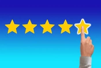 Una mano señalando la quinta estrella de una escala de valoración.